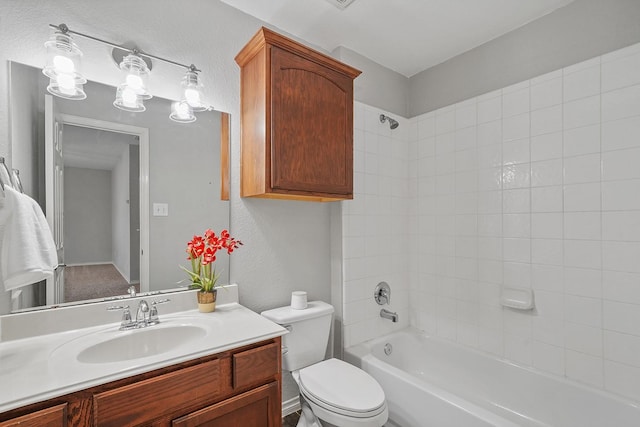 full bathroom featuring toilet, tiled shower / bath combo, and vanity