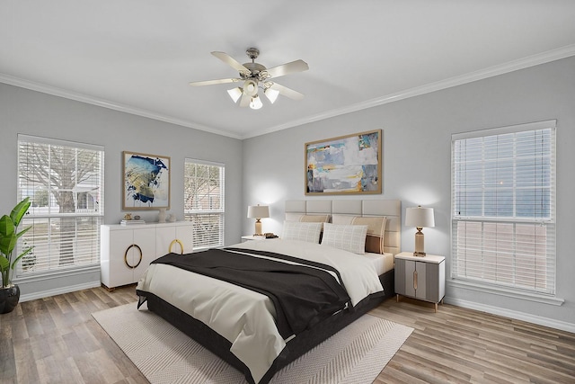 bedroom featuring ceiling fan, light wood-type flooring, and crown molding