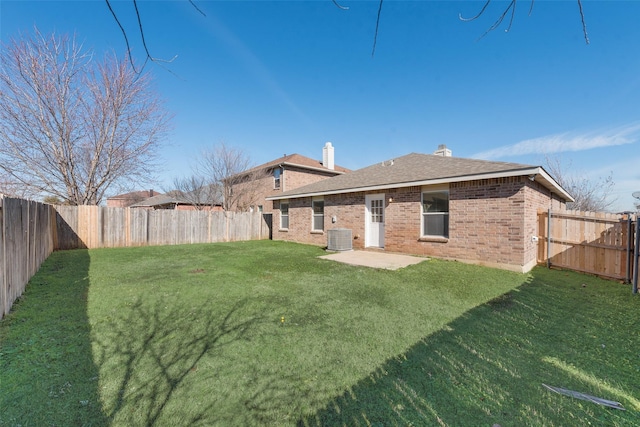 back of house with central AC, a yard, and a patio