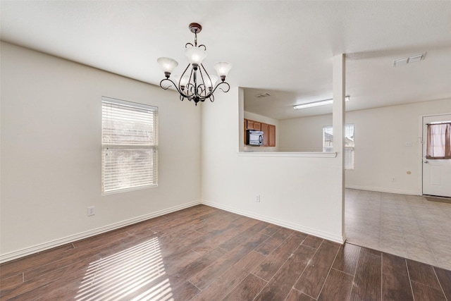 unfurnished room with an inviting chandelier