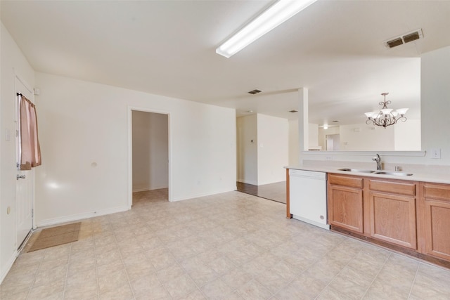 kitchen with dishwasher, sink, and a notable chandelier