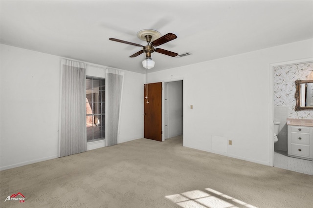 unfurnished bedroom with light carpet, ceiling fan, and ensuite bath