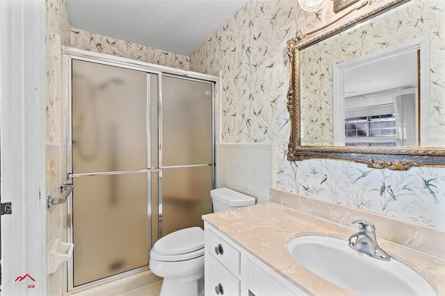 bathroom with a shower with shower door, vanity, and toilet