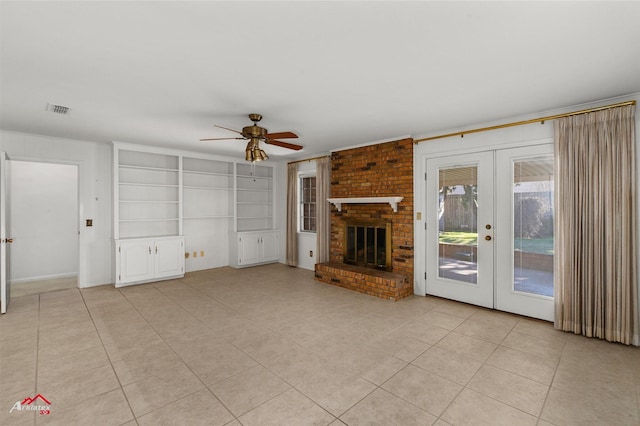 unfurnished living room with ceiling fan, french doors, a brick fireplace, and light tile patterned flooring