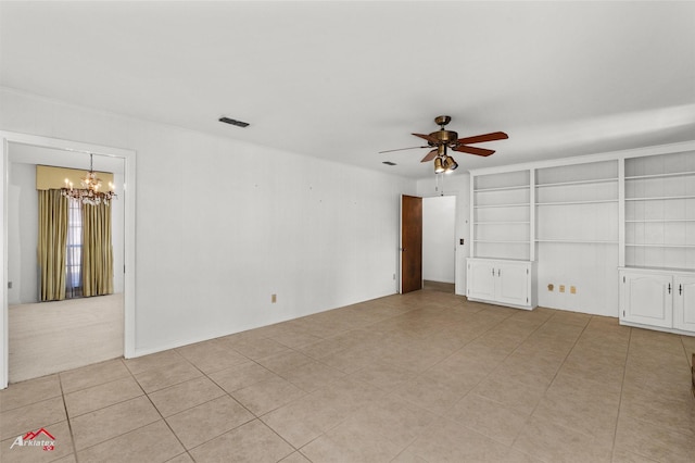 empty room featuring ceiling fan with notable chandelier