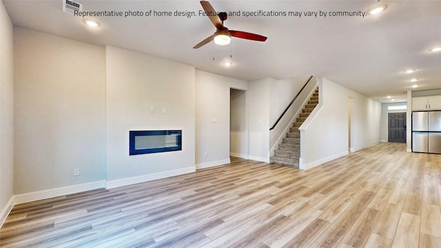 unfurnished living room featuring ceiling fan and light wood-type flooring