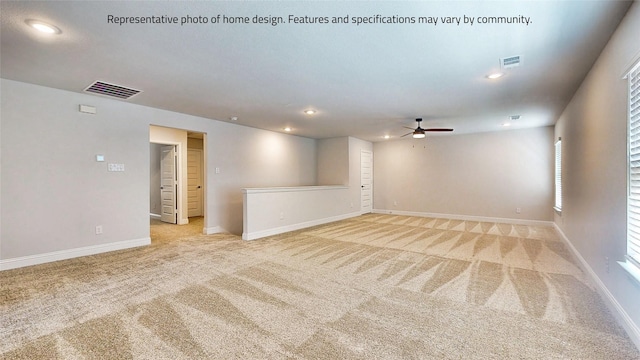 interior space featuring ceiling fan, light colored carpet, and a healthy amount of sunlight