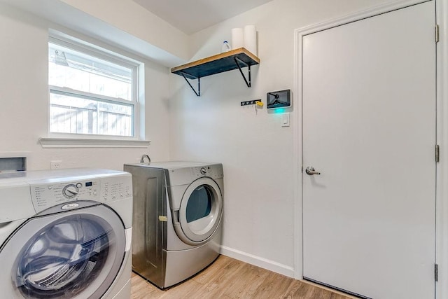 laundry room with washer and dryer and light hardwood / wood-style flooring