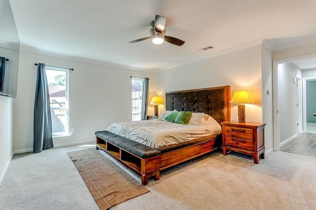 carpeted bedroom featuring ceiling fan and crown molding