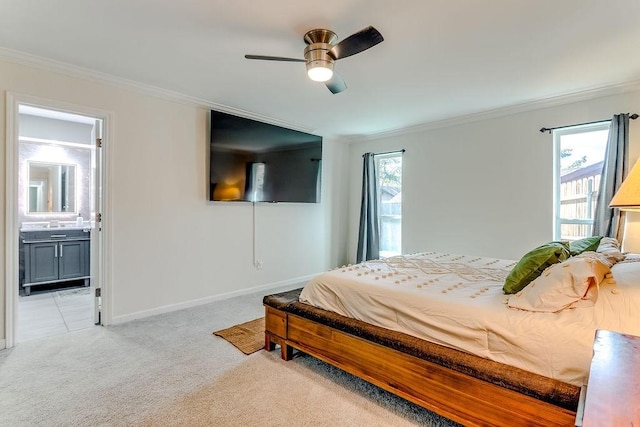 bedroom featuring light carpet, ceiling fan, ensuite bathroom, and crown molding