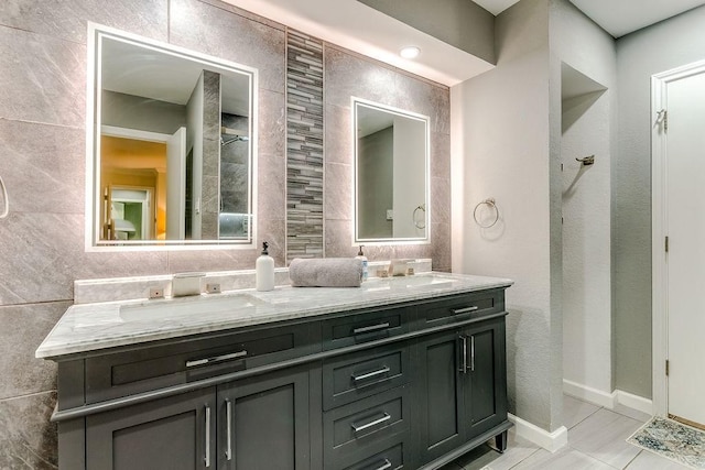 bathroom featuring tile walls, tile patterned floors, and vanity