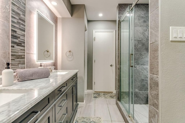 bathroom featuring an enclosed shower, vanity, tile patterned flooring, and tile walls