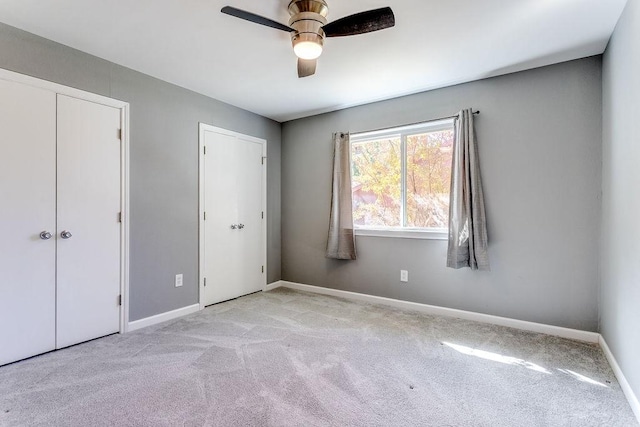 unfurnished bedroom featuring ceiling fan and light colored carpet