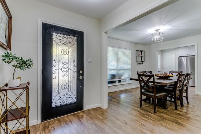 entryway featuring light hardwood / wood-style flooring and a notable chandelier