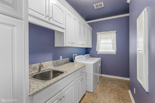 laundry area with cabinets, sink, crown molding, and washing machine and clothes dryer