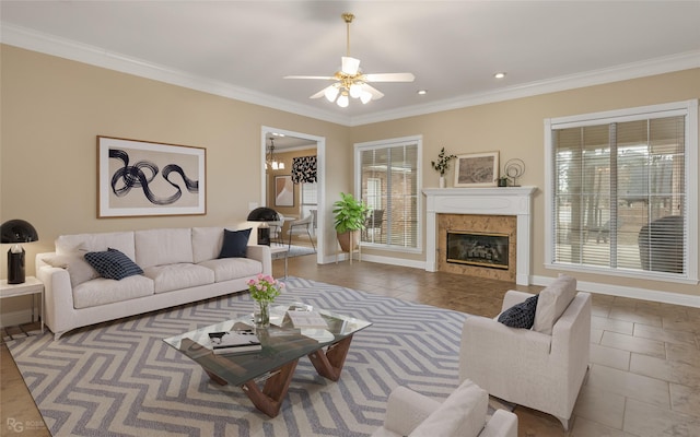 living room featuring ceiling fan, dark tile patterned flooring, a premium fireplace, and crown molding