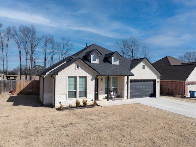 view of front facade featuring a front yard, covered porch, and a garage