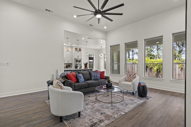 living room featuring ceiling fan and dark hardwood / wood-style floors