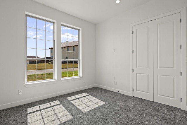 spare room featuring dark colored carpet