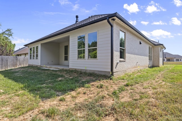 back of property featuring a yard