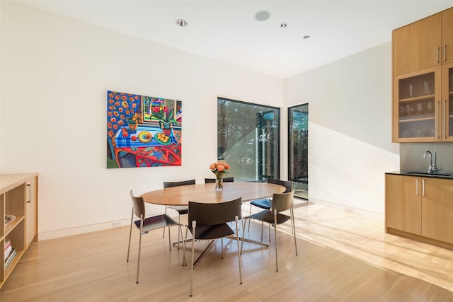 dining area featuring sink and light hardwood / wood-style flooring