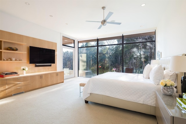 bedroom with ceiling fan, light colored carpet, access to exterior, and floor to ceiling windows