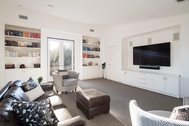 living room featuring french doors, built in features, and dark colored carpet