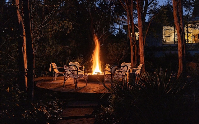 patio at night featuring an outdoor fire pit