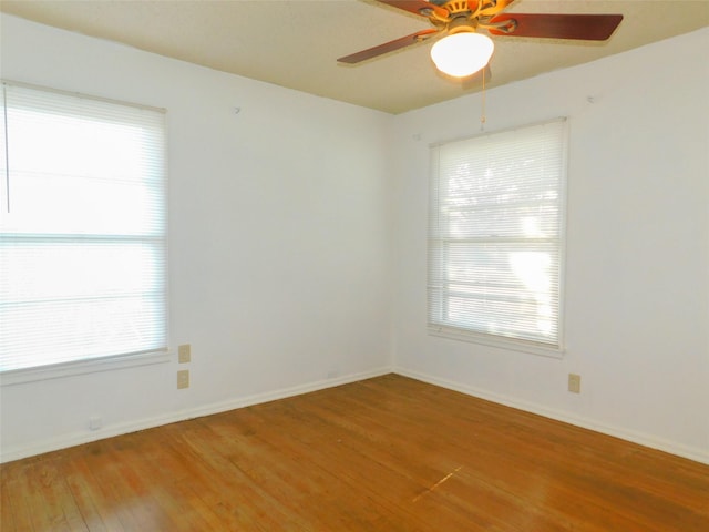 spare room featuring ceiling fan, a wealth of natural light, and hardwood / wood-style flooring