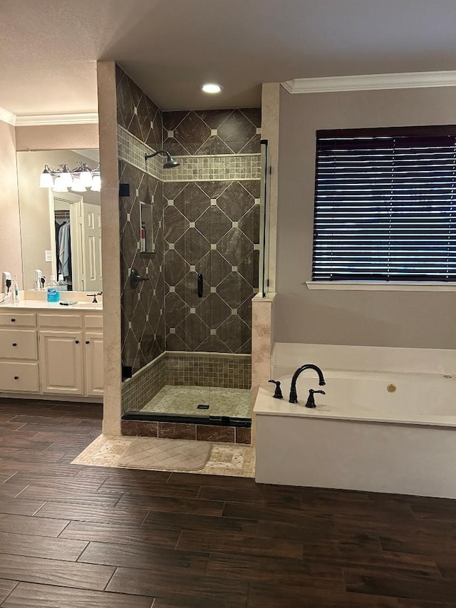 bathroom with hardwood / wood-style flooring, vanity, crown molding, and separate shower and tub