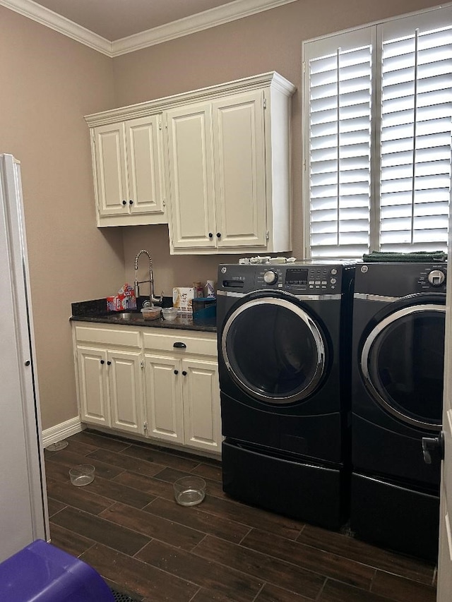 laundry area featuring sink, cabinets, washer and clothes dryer, and crown molding