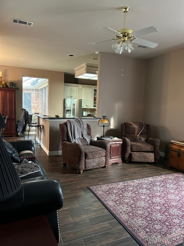 living room with ceiling fan and dark hardwood / wood-style flooring