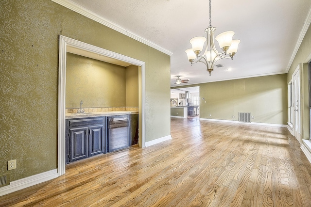 interior space with wine cooler, sink, pendant lighting, ornamental molding, and hardwood / wood-style flooring