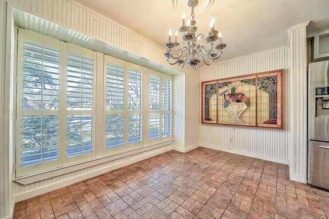 unfurnished dining area with a textured ceiling and a notable chandelier