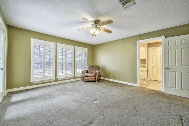 unfurnished room with light carpet, a textured ceiling, and ceiling fan