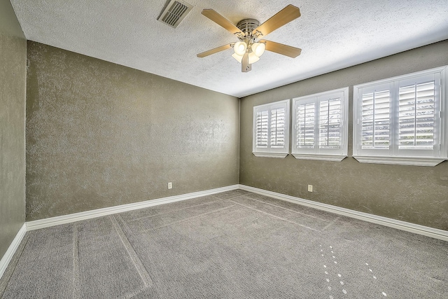 carpeted empty room with ceiling fan and a textured ceiling