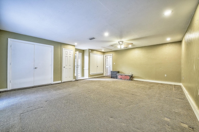 interior space with ceiling fan, carpet, and a textured ceiling