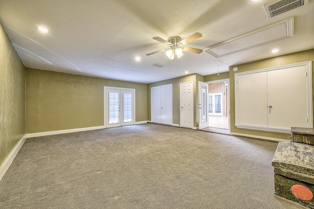 interior space with french doors, ceiling fan, carpet, and a textured ceiling