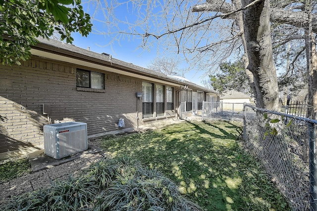 back of house featuring cooling unit and a yard