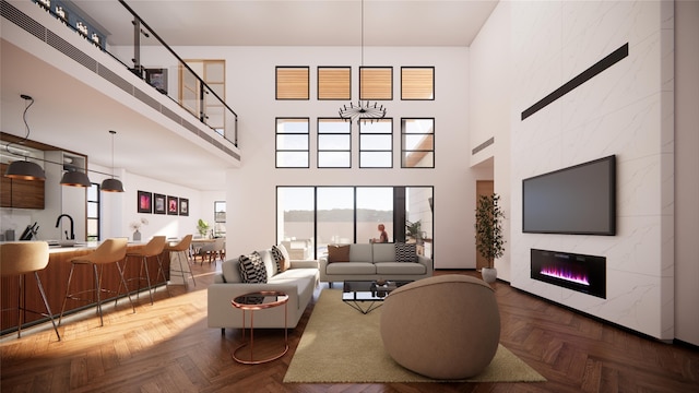 living room featuring a healthy amount of sunlight, a towering ceiling, and a tiled fireplace