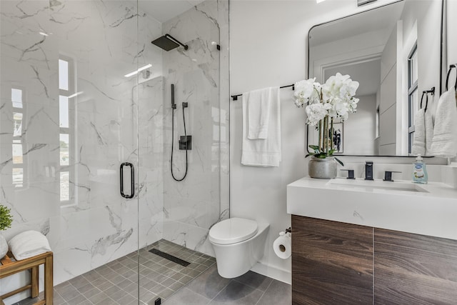 bathroom featuring toilet, a marble finish shower, and vanity