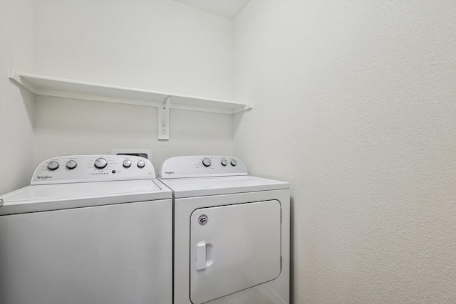 clothes washing area with washer and clothes dryer