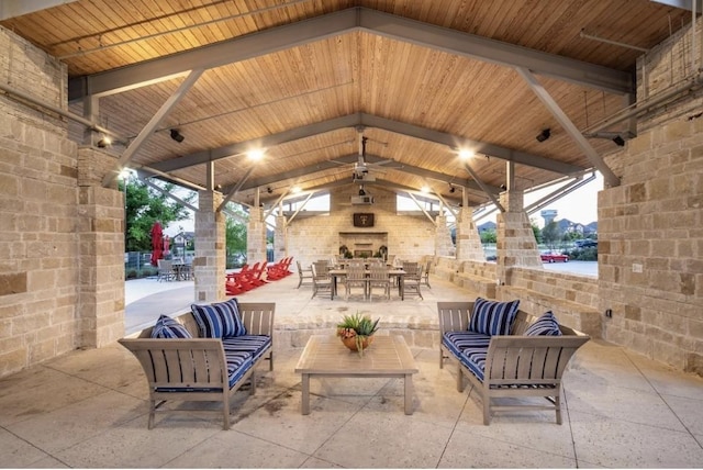 view of patio / terrace with a gazebo, ceiling fan, and an outdoor living space with a fireplace