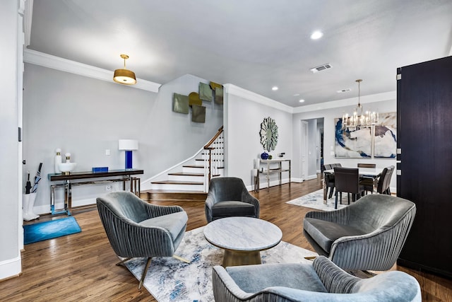 living room with dark hardwood / wood-style floors, crown molding, and a chandelier