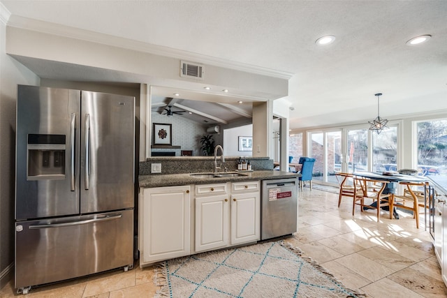 kitchen featuring appliances with stainless steel finishes, white cabinetry, vaulted ceiling with beams, sink, and ornamental molding