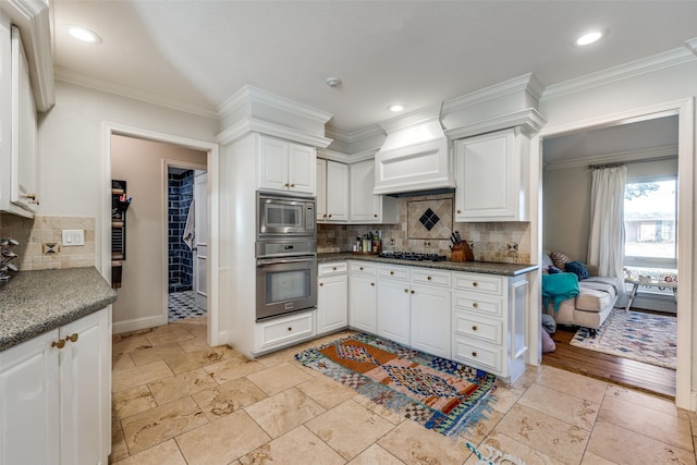 kitchen with stainless steel appliances, decorative backsplash, ornamental molding, and white cabinetry