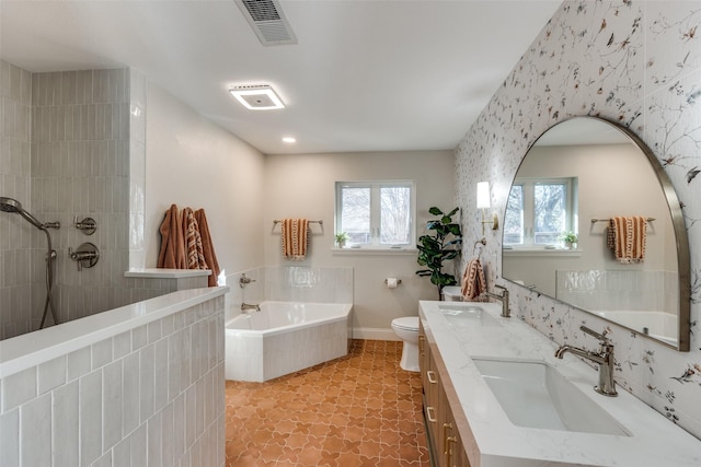 bathroom with a relaxing tiled tub, toilet, vanity, and tile patterned flooring