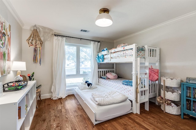 bedroom with ornamental molding and dark hardwood / wood-style floors