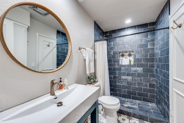 bathroom with a textured ceiling, a shower with shower curtain, toilet, and vanity