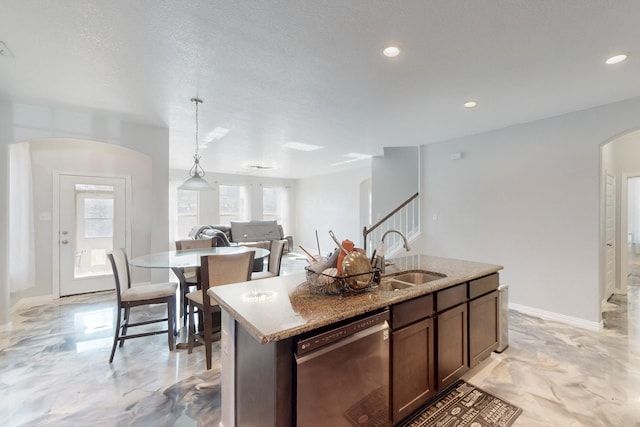 6217 Jackstaff Dr, Fort Worth, TX 76179 - kitchen with stainless steel dishwasher, a sink, arched walkways, baseboards, and light stone countertops